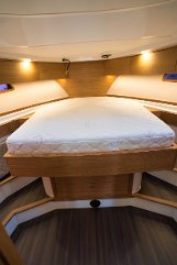 Ambiente Master Suite Falegnameria elegante e biancheria confortevole nella cabina principale di 'Baby Blue'.