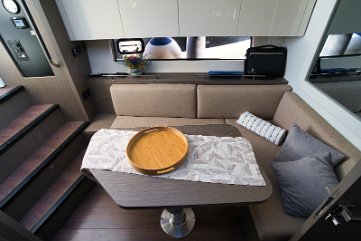 Innenlounge - Beneteau GT 41 Das L-förmige Sofa im Salon bietet einen komfortablen Rückzugsort mit Klimaanlage.