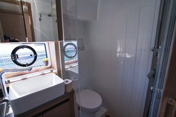 Badezimmer-Design Moderner Waschraum mit stilvollem Waschbecken, Stauraum und elektrischem WC.
